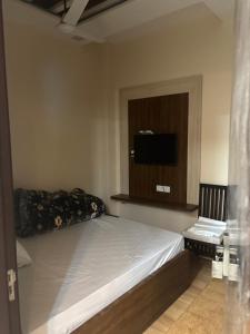 a bedroom with a bed and a tv on the wall at SEVEN SEVEN HOMESTAy in Amritsar