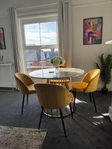 a dining room with a table and chairs and a window at Stylish One Bedroom Apartment in Norwich