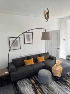 a living room with a black couch and yellow pillows at Luxury One Bedroom Apartment in Norwich +2 photos