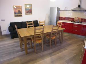 a kitchen and dining room with a wooden table and chairs at Apartment La Gatta Viola in Stresa +41 photos