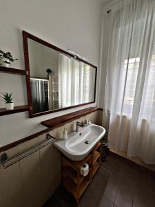 ein Badezimmer mit Waschbecken, Spiegel und Fenster in der Unterkunft Eagle's Nest in Polignano a Mare + 36 Fotos