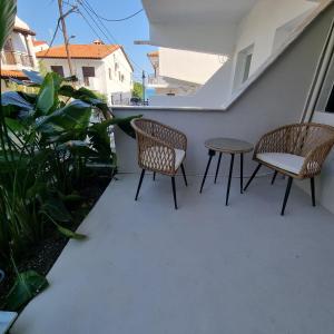 two chairs and a table on a patio at Vaios Luxury Apartments in Polykhrono