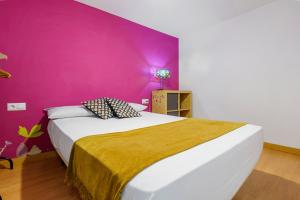 Un dormitorio con una cama grande con una pared morada. en Plaça la Font, en Tarragona