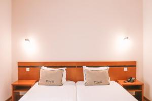 Postel nebo postele na pokoji v ubytování Vitoria Hotel