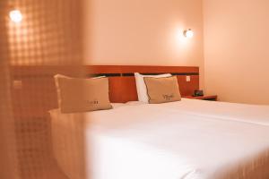 Postel nebo postele na pokoji v ubytování Vitoria Hotel