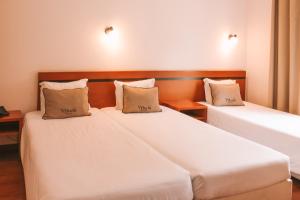 Postel nebo postele na pokoji v ubytování Vitoria Hotel