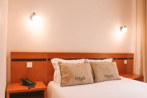 Postel nebo postele na pokoji v ubytování Vitoria Hotel