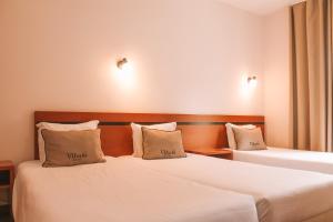 Postel nebo postele na pokoji v ubytování Vitoria Hotel