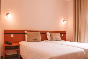 Postel nebo postele na pokoji v ubytování Vitoria Hotel