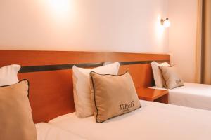 Postel nebo postele na pokoji v ubytování Vitoria Hotel