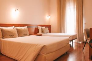 Postel nebo postele na pokoji v ubytování Vitoria Hotel