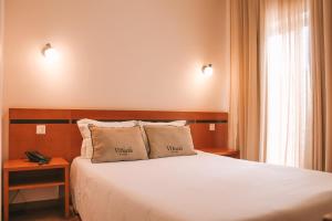 Postel nebo postele na pokoji v ubytování Vitoria Hotel