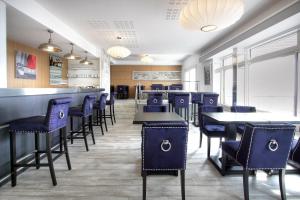 a restaurant with blue chairs and tables and a bar at Hôtel La Petite Sirène Quiberon in Quiberon
