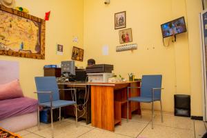 a room with a desk with a computer and two chairs at Hostel Afgo Rooftop in Ouarzazate