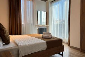 a bedroom with a bed and a large window at Rooms Apart Hotel by RED in Yerevan