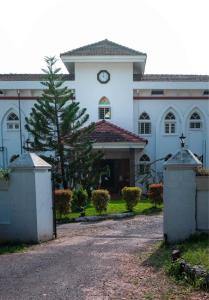 a large white building with a clock on it at Gama Heritage Residency in Cochin