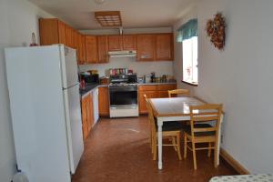 eine Küche mit einem Tisch und einem weißen Kühlschrank in der Unterkunft All Seasons B&B in Kenai