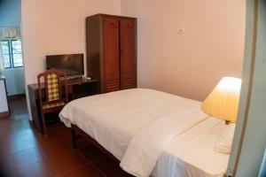 a bedroom with a bed and a dresser and a television at Gama Heritage Residency in Cochin