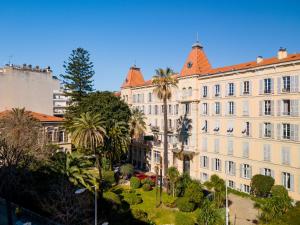 ニースにあるNice Renting - VICTOR - Historic Palace Luxury 3 Bedrooms Parkingのヤシの木が前に生えている大きな建物