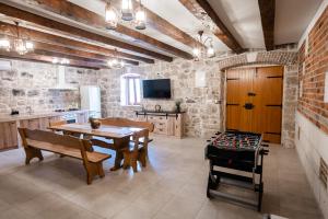 a large kitchen with a table and a game room at Didova kuća, kamena vila sa bazenom u blizini Rogoznice in Podorljak
