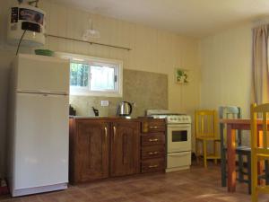 a kitchen with a white refrigerator and a stove at VerdeMonte - Cabaña Anchico in Leandro N. Alem