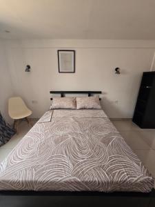 a large bed in a white room with a bedskirtspectspectspects at Ndap Ma Xa in Yaoundé