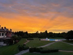 a sunset over a house and a swimming pool at Terme Colli Golf - Suite La Montecchia in Montecchia