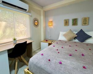 a bedroom with a bed with pink flowers on it at Colorful Garden House in Providencia