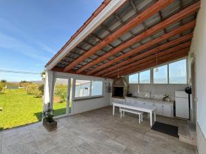 a pavilion with a table and a bench on a patio at Carnota Beach in Carnota