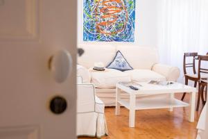 a living room with a white couch and a table at Ventoura Suites, Corfu Old Town in Corfu