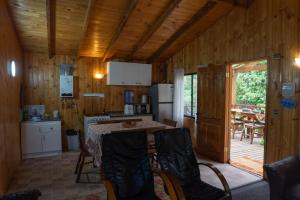a kitchen with a table and chairs in a cabin at Cabañas Altos de carewe 2, Lican Ray Chile in Licán Ray