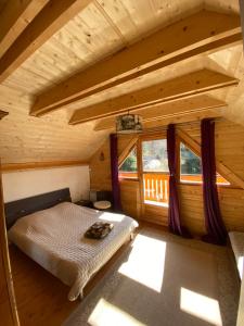 a bedroom with a bed in a log cabin at Chalet Mon Beau Sapin lisière de Forêt - Vue montagne - Gerardmer in Anould