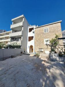 ein großes Mehrfamilienhaus mit Parkplatz in der Unterkunft Studio apartman za 2 uz more in Makarska