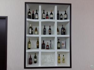 a shelf filled with bottles and glasses on a wall at Marinella in Telavi