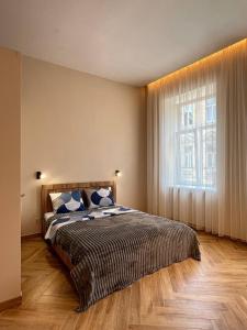 a bedroom with a bed and a large window at PushApart Lviv in Lviv