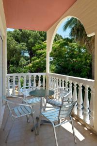 een patio met 2 stoelen en een tafel op een veranda bij Perla Marina Aparthotel in Ialyssos