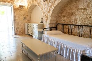 Un dormitorio con dos camas y una pared de piedra. en Agriturismo Masseria Carrone, en Carovigno