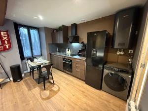 a kitchen with a black refrigerator and a table at L'escale en Othe avec jacuzzi in Estissac