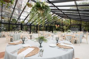 a wedding reception in a greenhouse with white tables and chairs at Castilla Termal Solares in Solares +37 photos