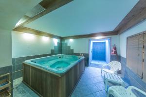 a large bathroom with a jacuzzi tub in it at Logis Hotel Gai Soleil in Samoëns