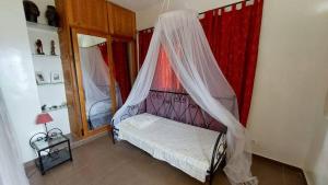 un dormitorio con una cama con mosquitera en B&B Pieds dans l'eau, en Poponguine