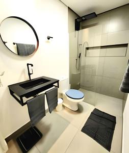 a bathroom with a toilet and a mirror at 2 DTS - Bela Vista - espaçoso + aconchegante in Sao Paulo