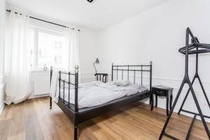 a bedroom with a black bed and a window at Apartament August in Gdynia