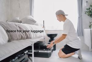東京にあるCosmoのスーツケースを持ってベッドの横にひざまずく男性