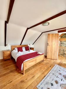 a bedroom with a bed and a wooden floor at Ysgubor in St. Davids