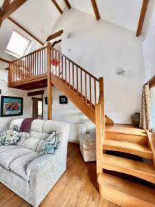 a living room with a staircase and a couch at Ysgubor in St. Davids +14 photos