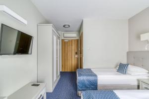 a hotel room with two beds and a flat screen tv at Hotel Aqua Sopot - Destigo Hotels in Sopot