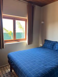 a blue bed in a room with a window at The Ocean Breeze bungalow in Sidi Kaouki +35 photos