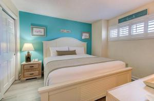 Un dormitorio con una cama y una pared azul. en 0411 Seaside Sunrise by Atlantic Towers, en Carolina Beach