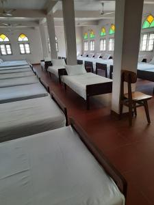 a row of beds in a room with stained glass windows at Gama Heritage Residency in Cochin
